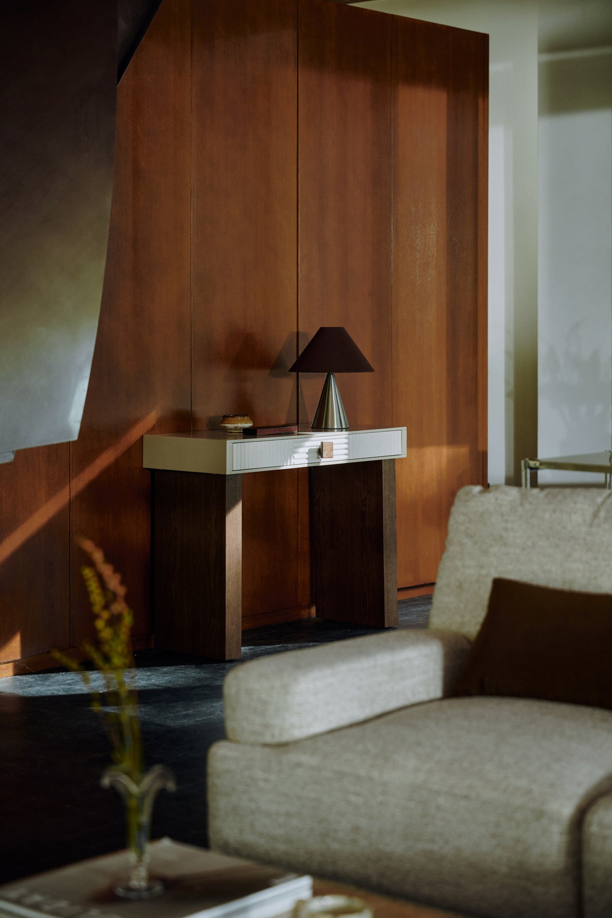 lampe de table Khone à abat-jour bordeaux posée sur la console Archi laquée crème