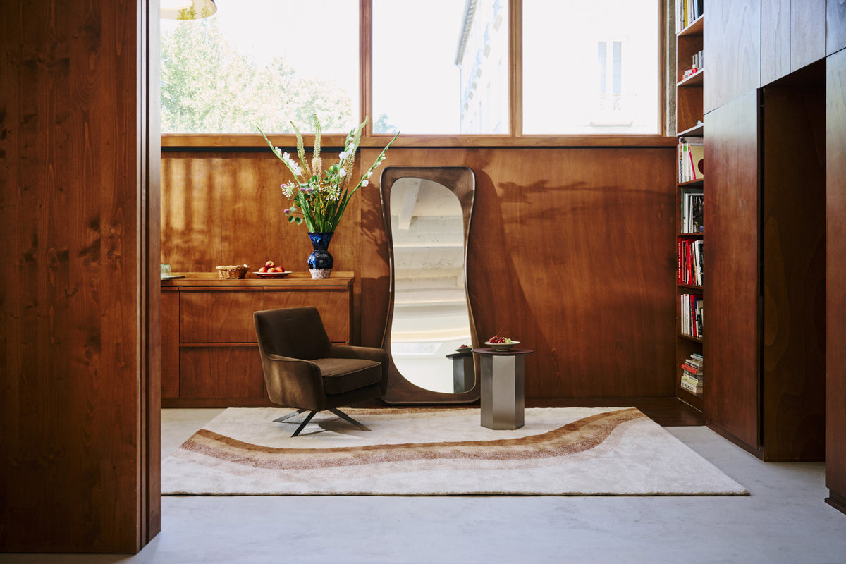 tapis de salon Levante écru à vague caramel dans un coin lecture aux murs en bois