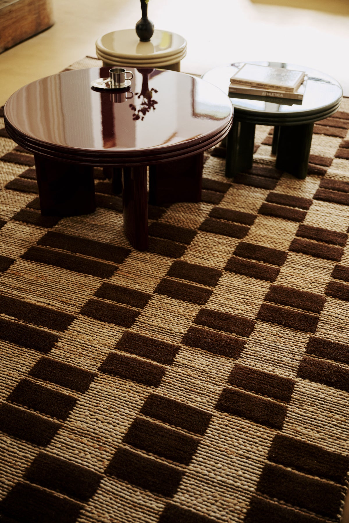 salon à cheminée avec tapis Saxton en jute à damier brun et table basse laquée marron