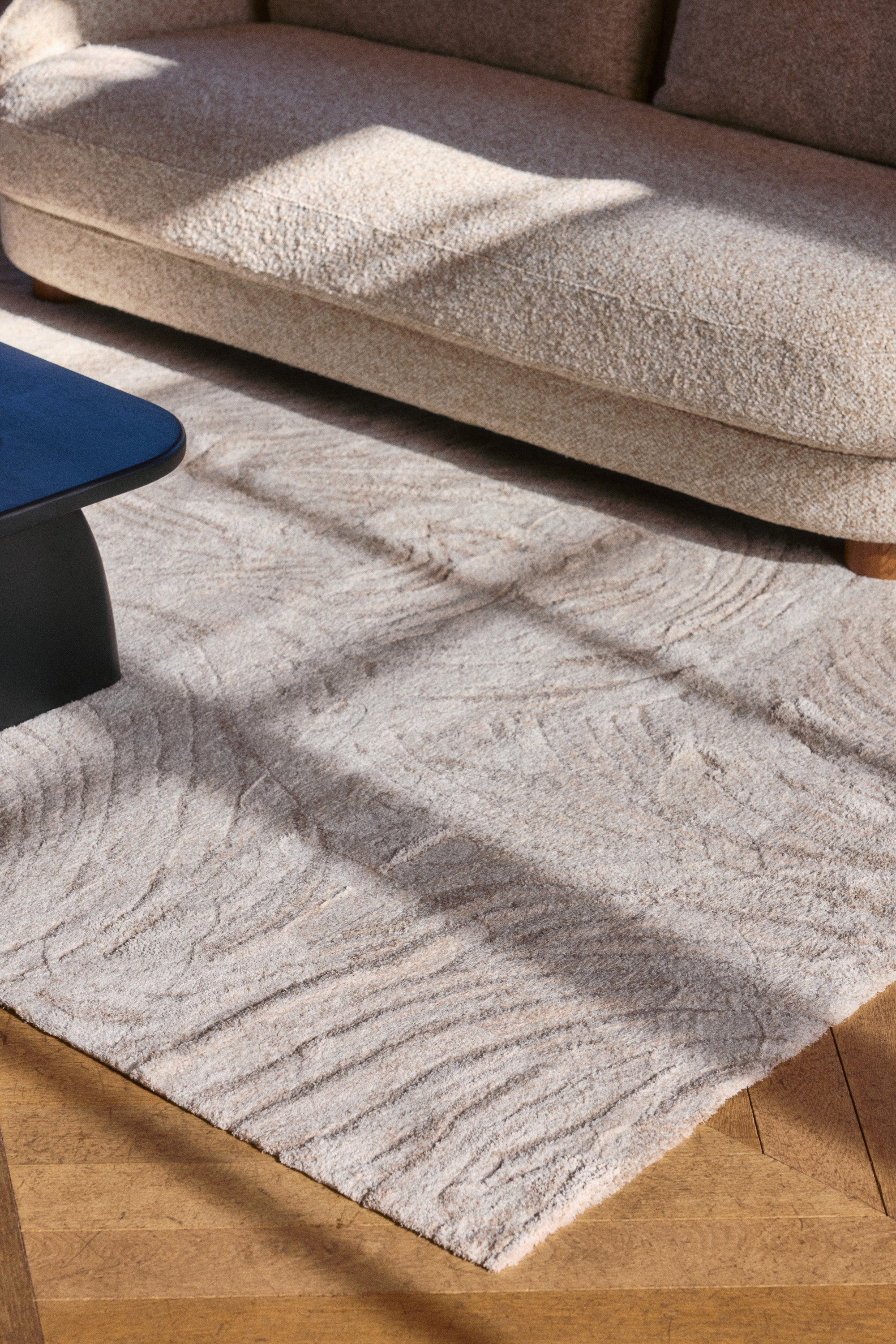 tapis Sablea - laine beige sable motif organique - vue plongeante salon avec canapé bouclé