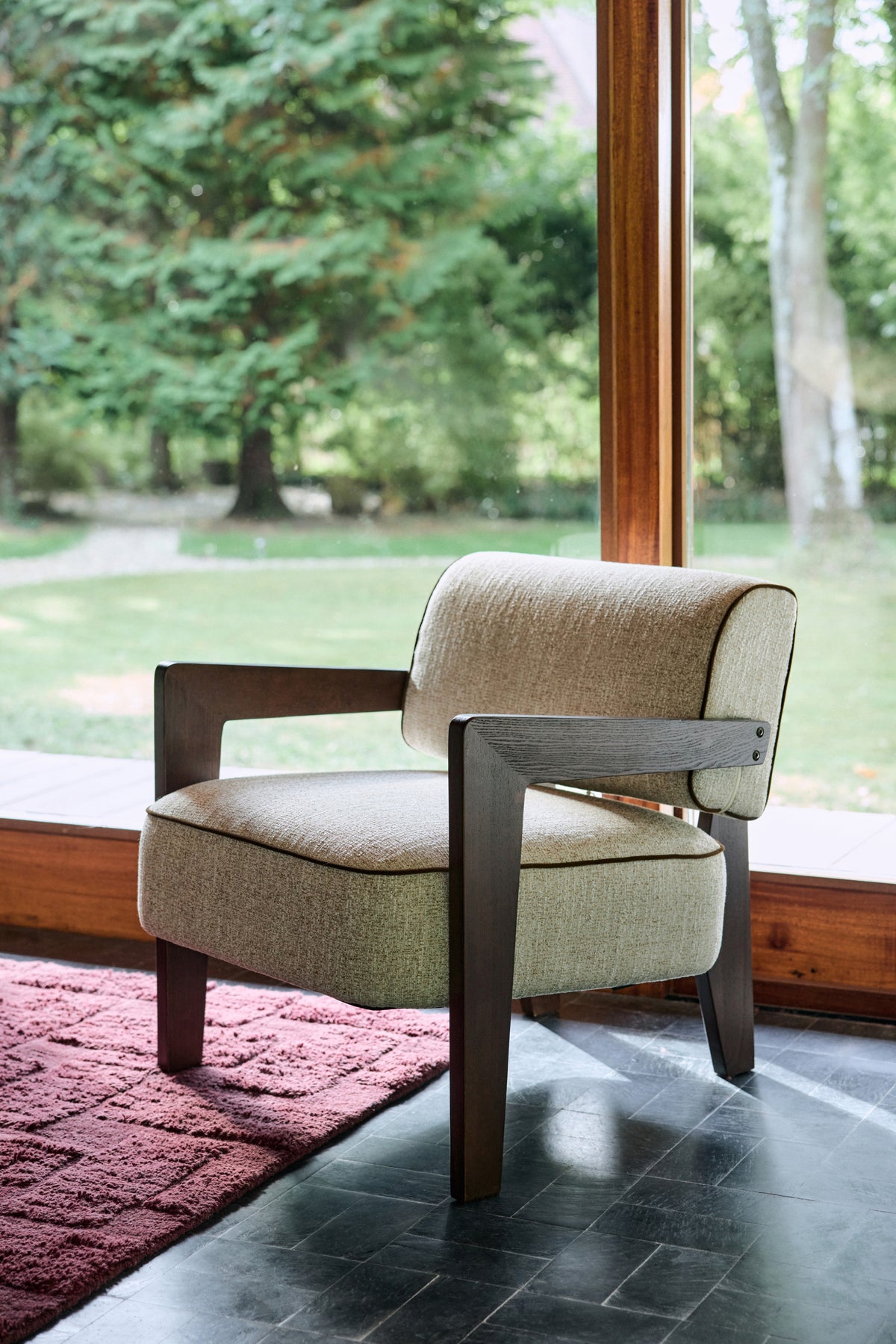 fauteuil Elvia écru et repose-pieds assorti - vue de trois-quarts sur tapis prune
