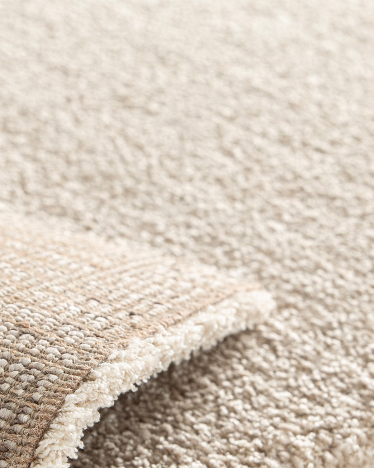 gros plan sur le velours beige et l'envers tissé naturel d'un tapis de salon Folio
