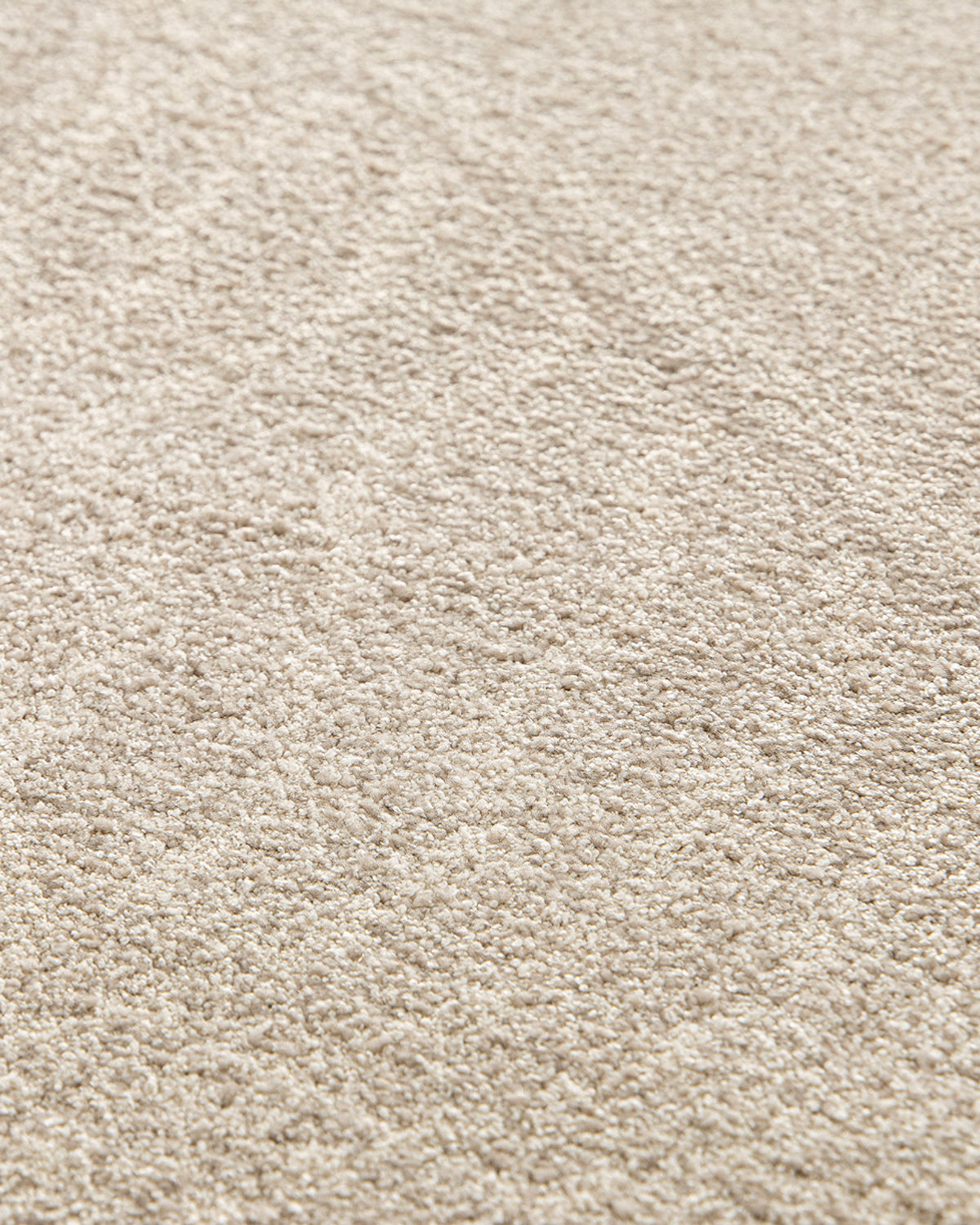 gros plan sur la densité et le relief sculpté du velours beige d'un tapis de salon Folio