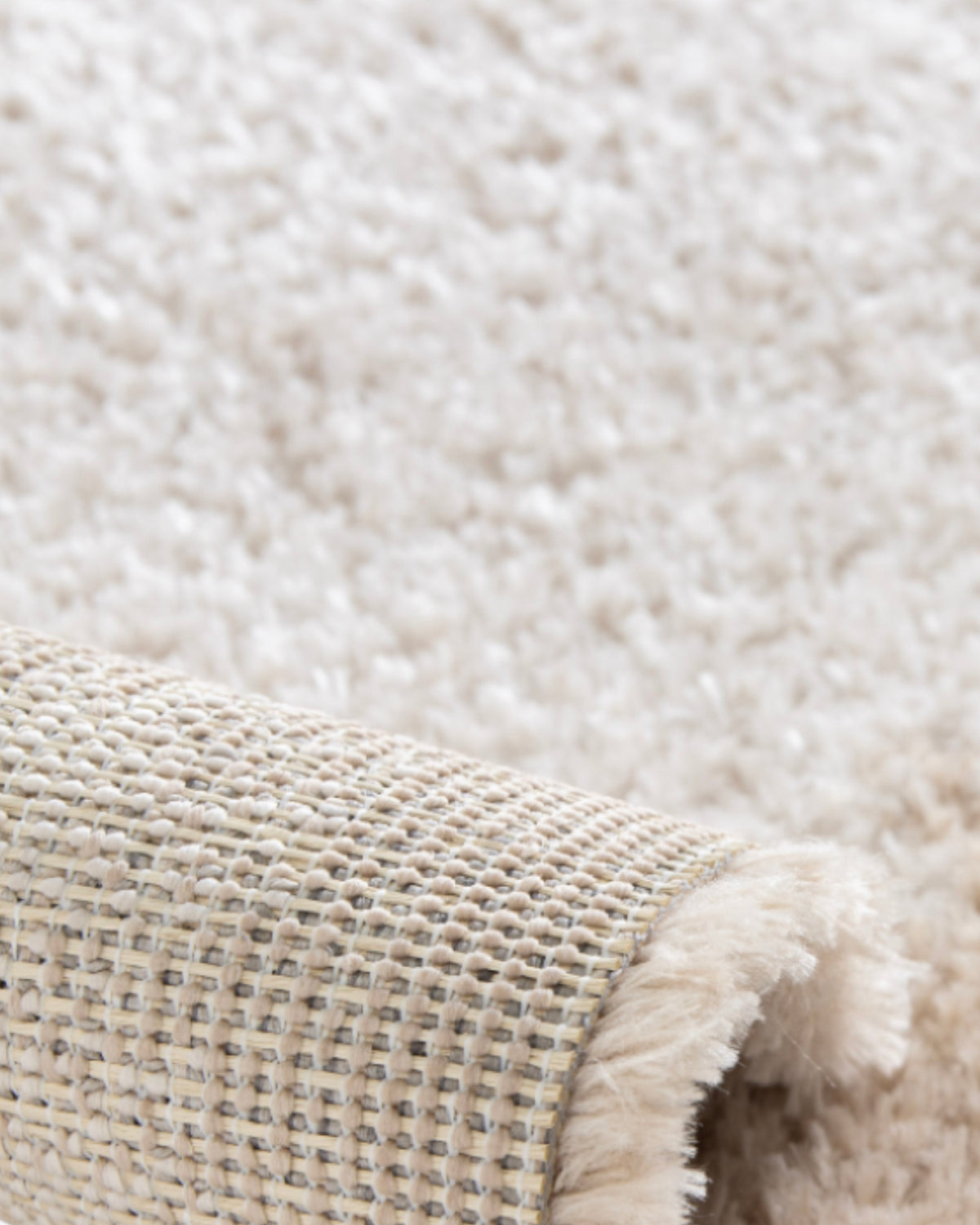 coin replié du tapis SENNEN, hauteur du velours écru et envers tissé beige et gris