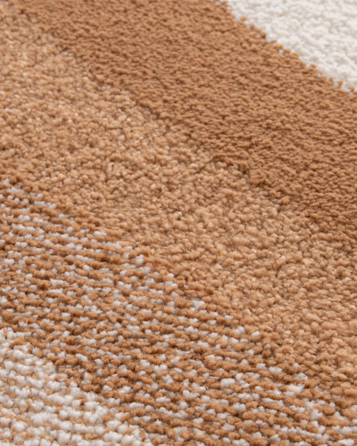 gros plan sur le fondu moucheté entre le caramel et l'écru d'un tapis de salon Levante