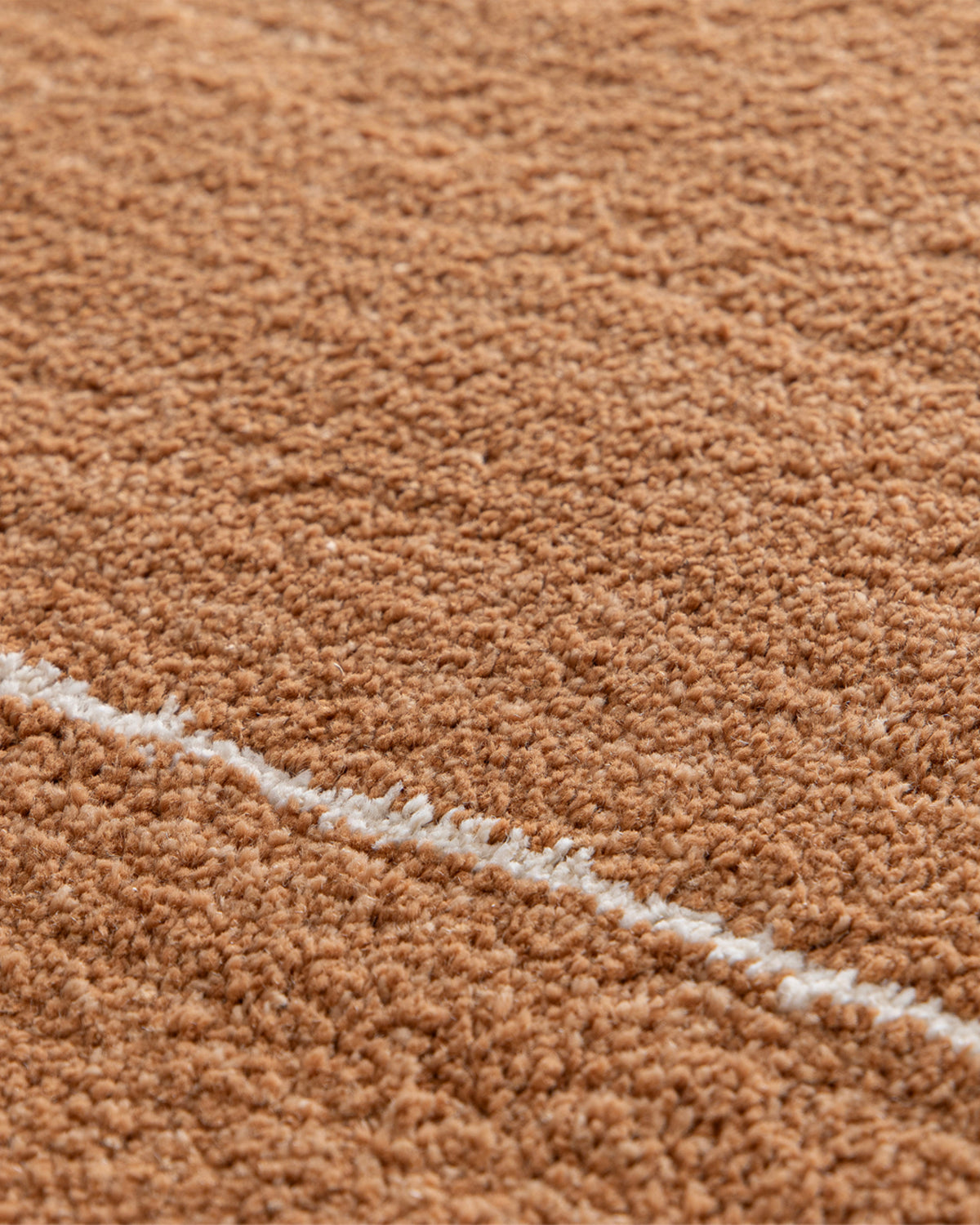 gros plan sur la ligne écrue et la densité du velours d'un tapis Crest en polypropylène