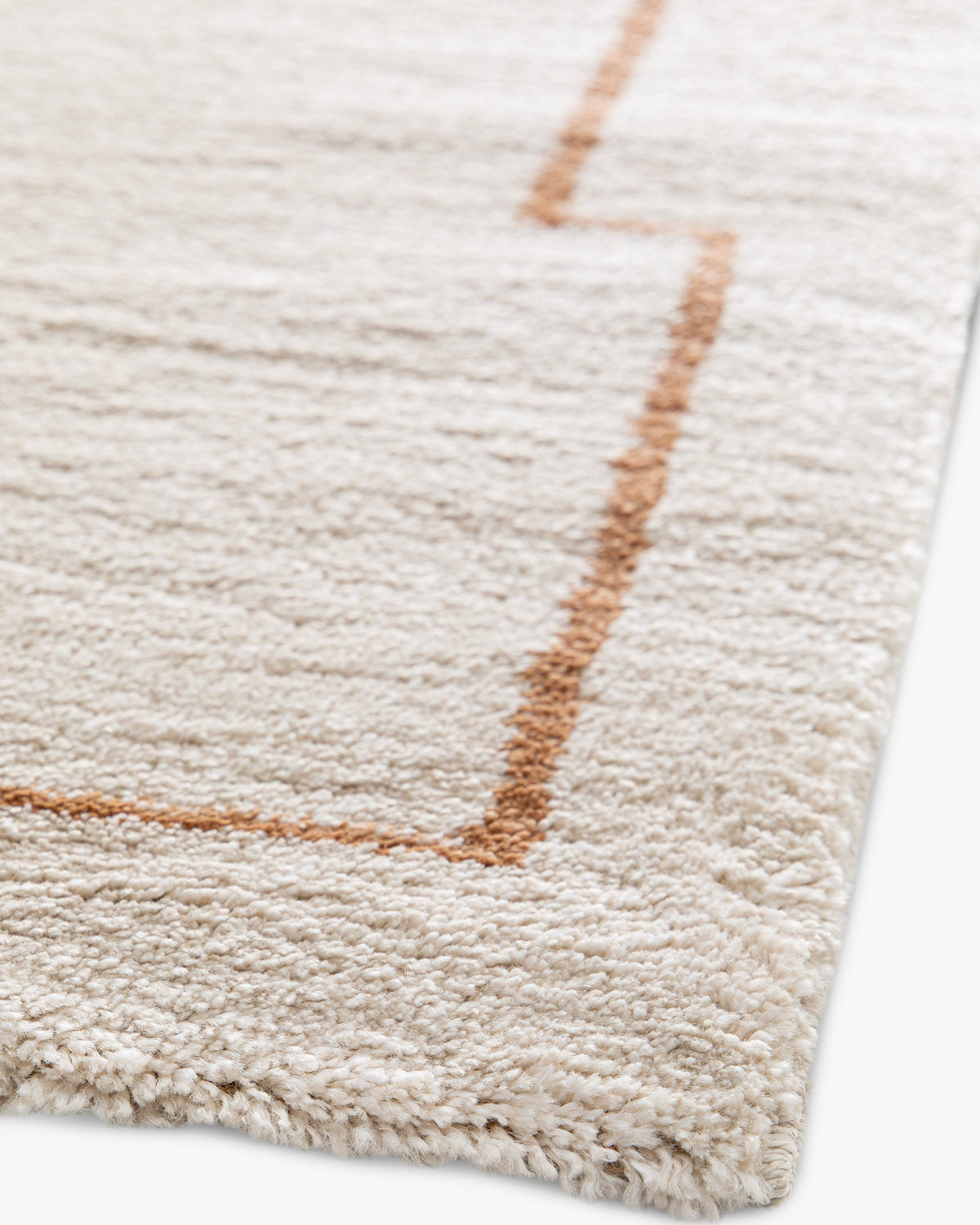 gros plan sur le tracé terracotta à créneaux d'un tapis Crest en polypropylène écru