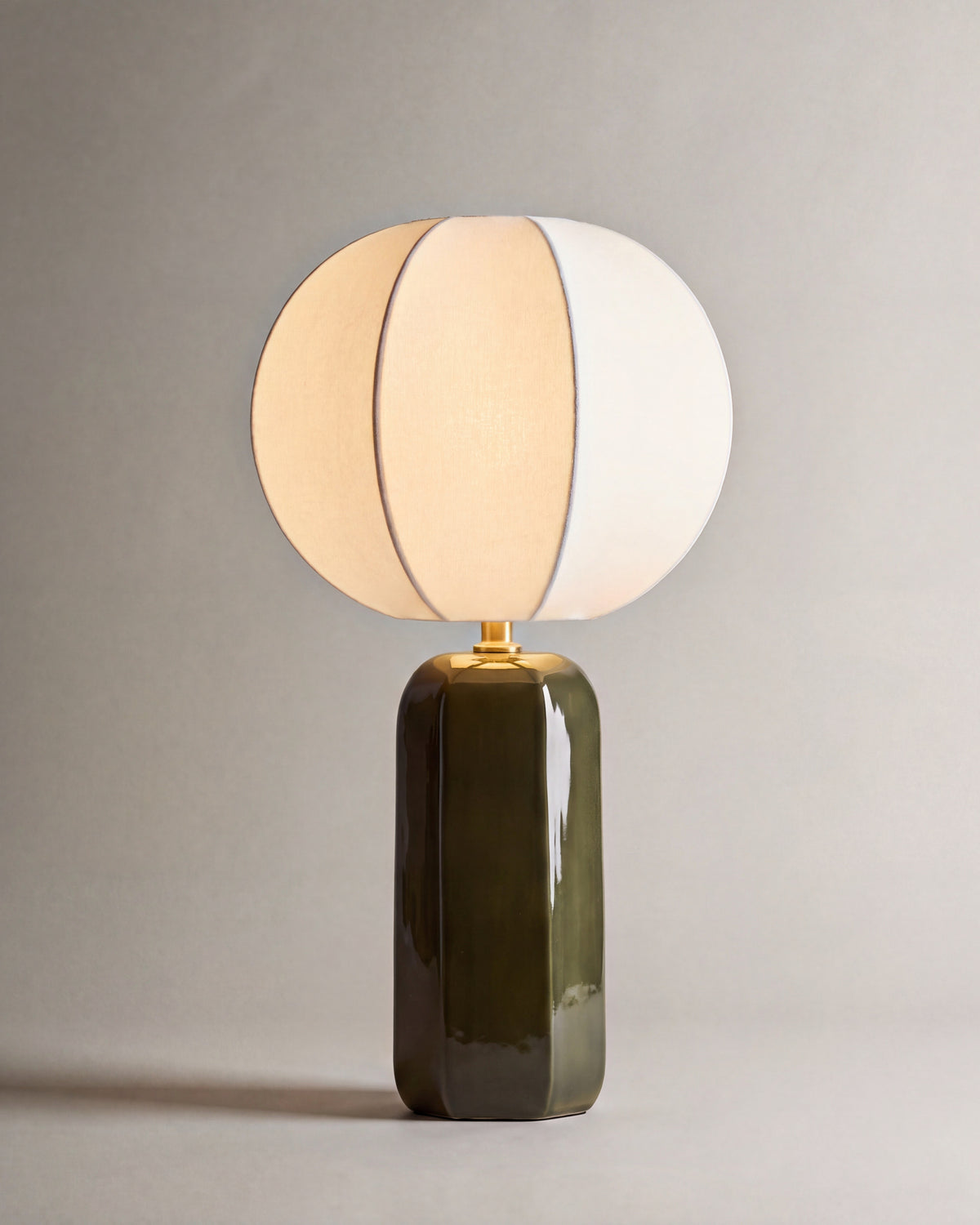 lampe de table AGATHE allumée, pied en céramique vert kaki et abat-jour écru à lobes