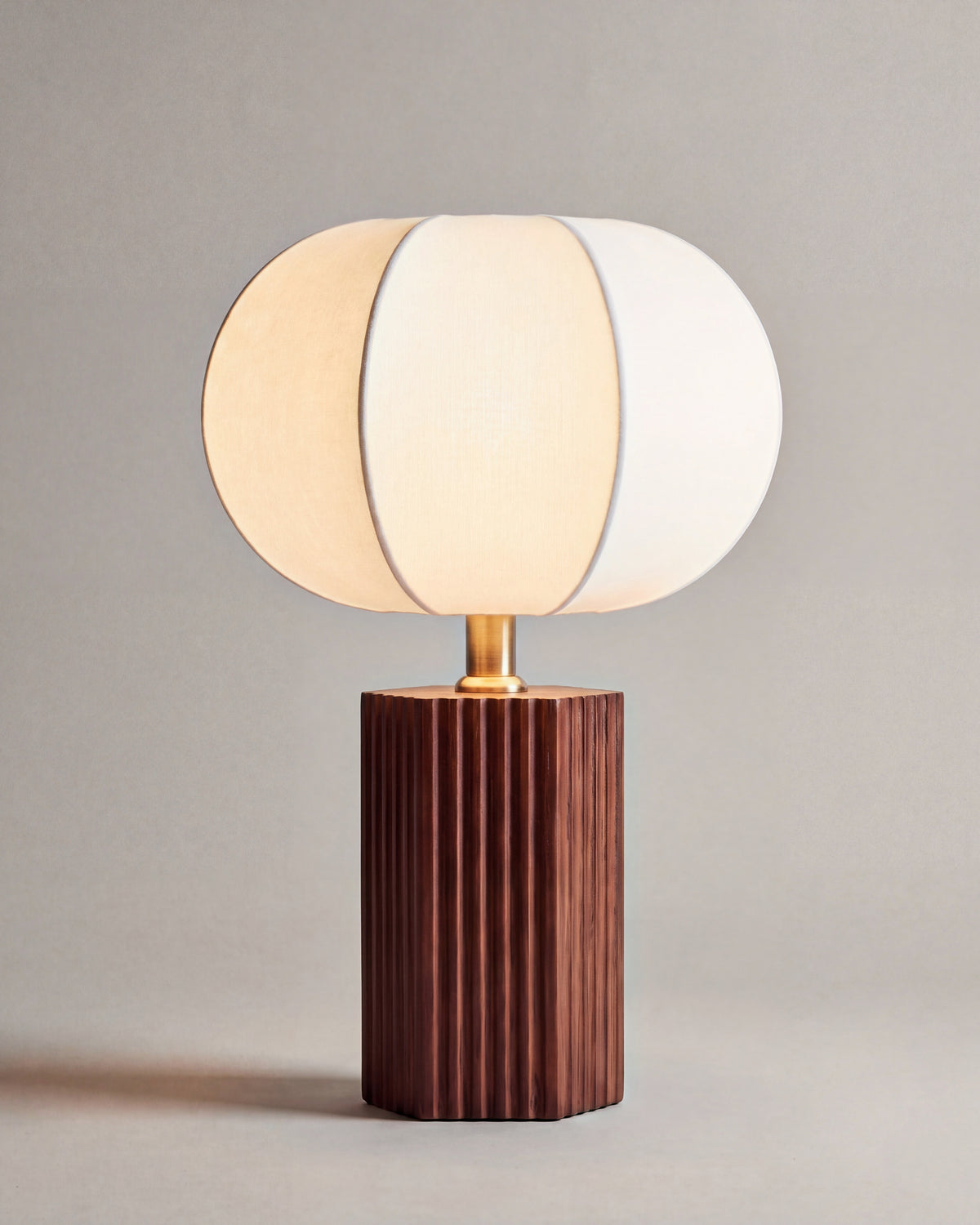 lampe de table AVAI allumée, pied cannelé en noyer et abat-jour en lin écru à lobes