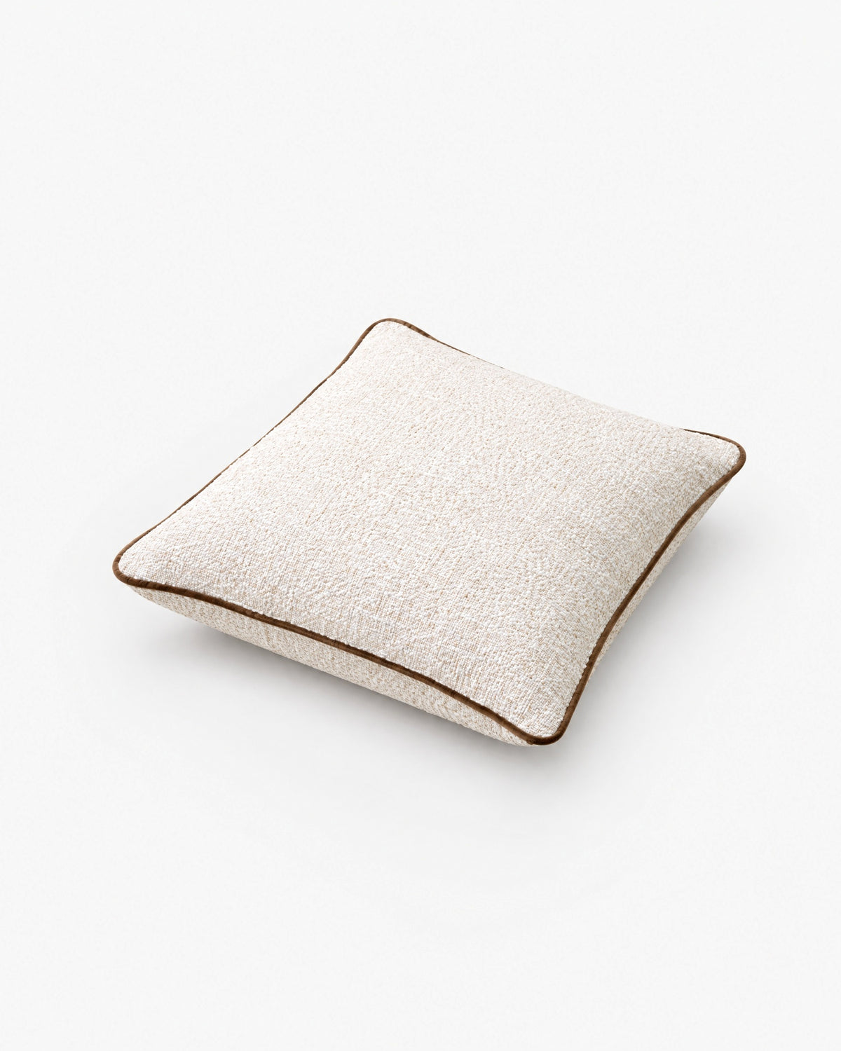 coussin carré CARIBOU en bouclé écru à passepoil marron, vue de trois quarts en plongée