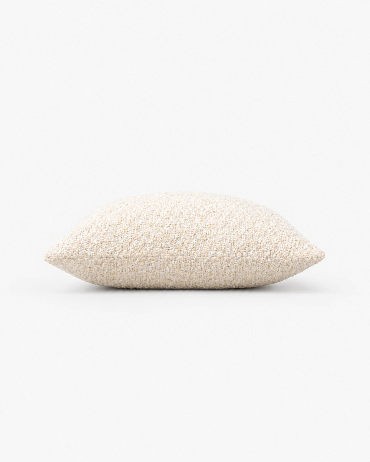 coussin carré CASTLE en bouclé écru vu de profil, épaisseur et couture simple visibles