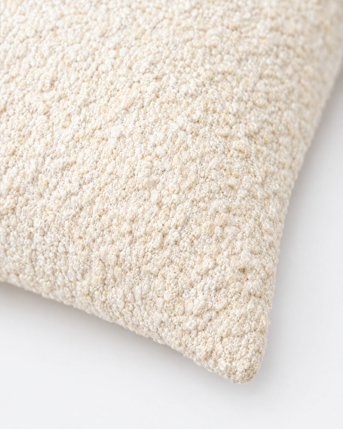 gros plan sur les boucles serrées du tissage écru et beige clair du coussin CASTLE