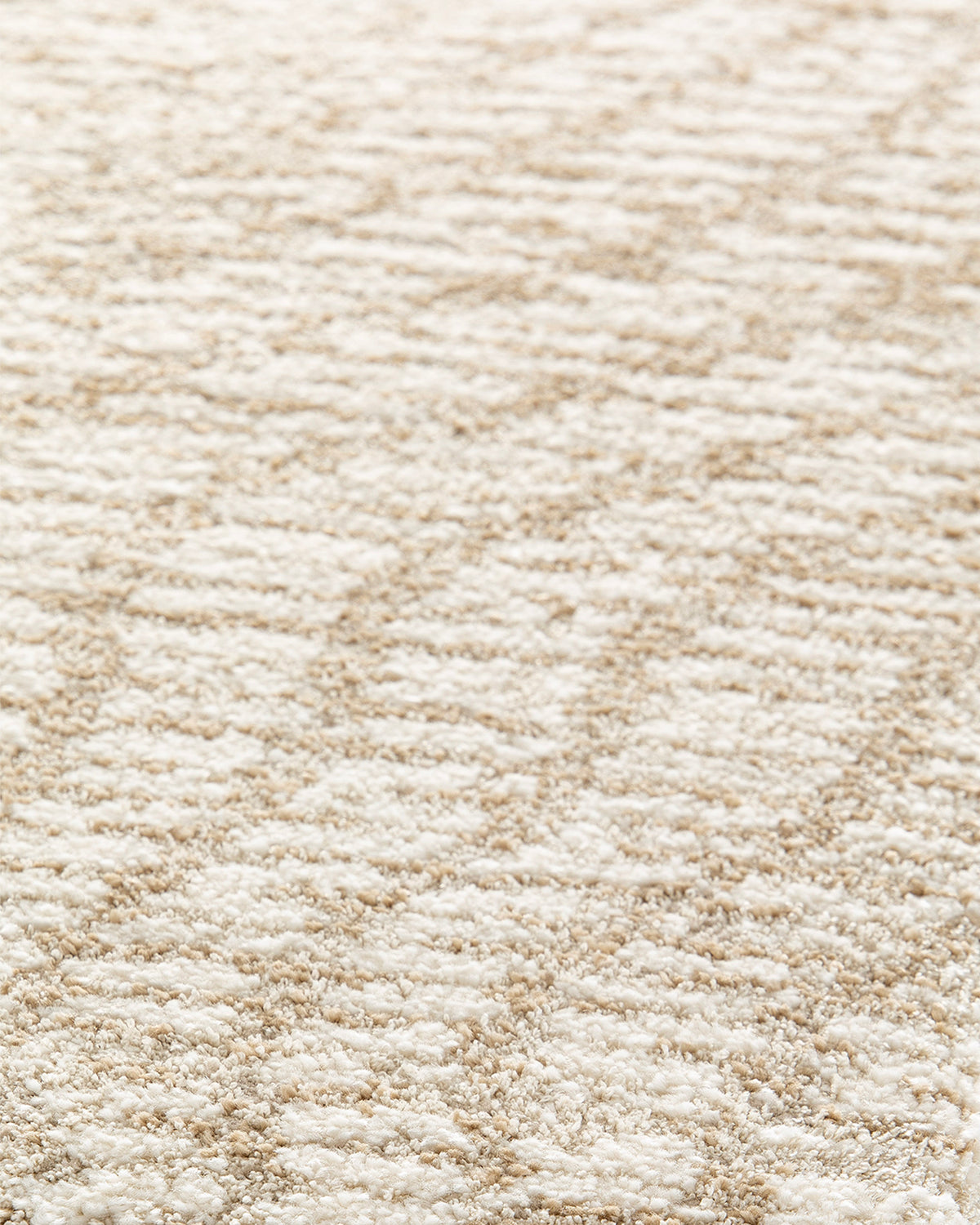 gros plan sur les fines hachures sable d'un tapis de salon Cortex écru en grand format