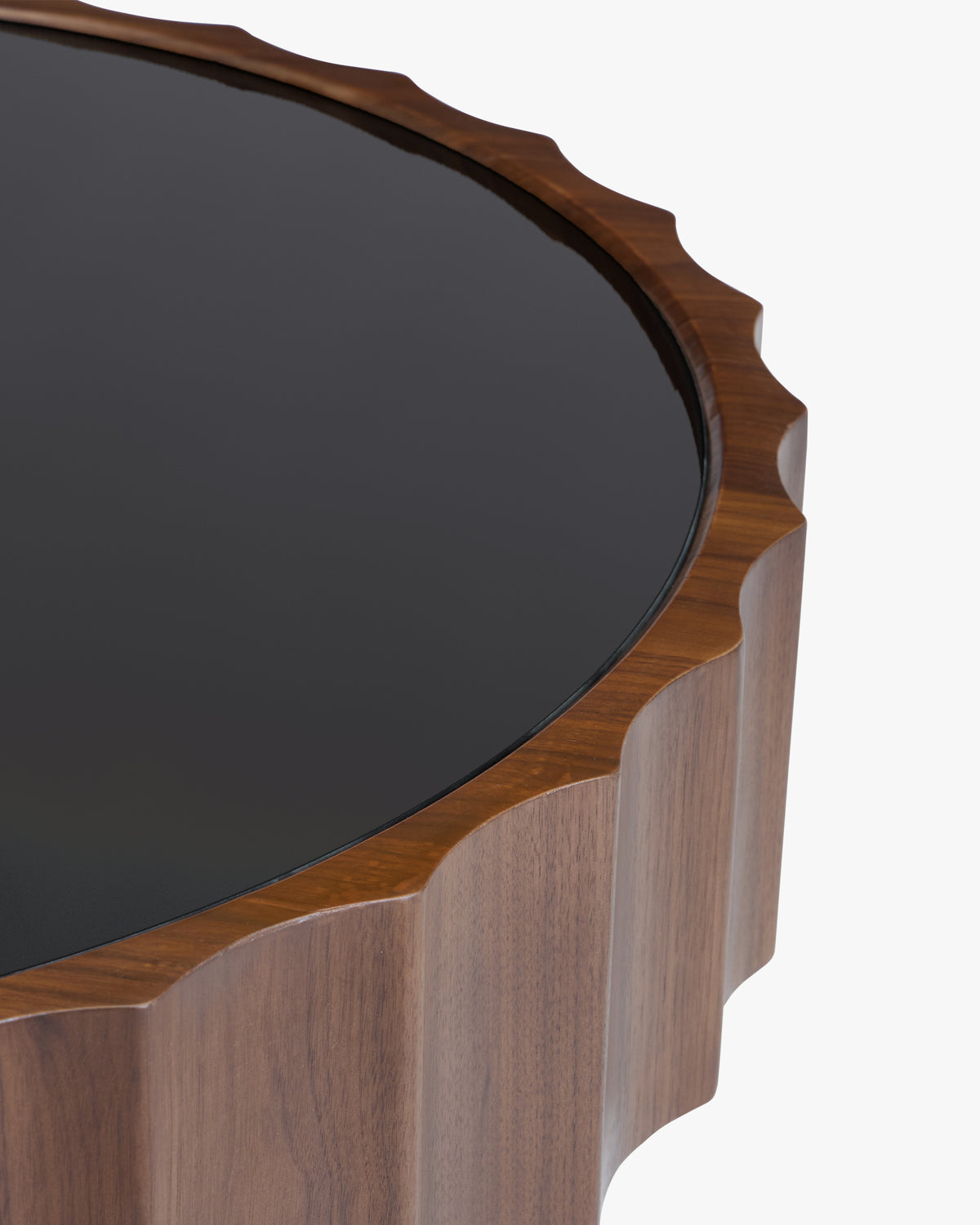 gros plan sur le plateau en verre fumé noir posé dans la ceinture cannelée d'une table CANNELATA