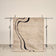 tapis DRIFT beige à courbes noires, petit format suspendu sur un portant de studio