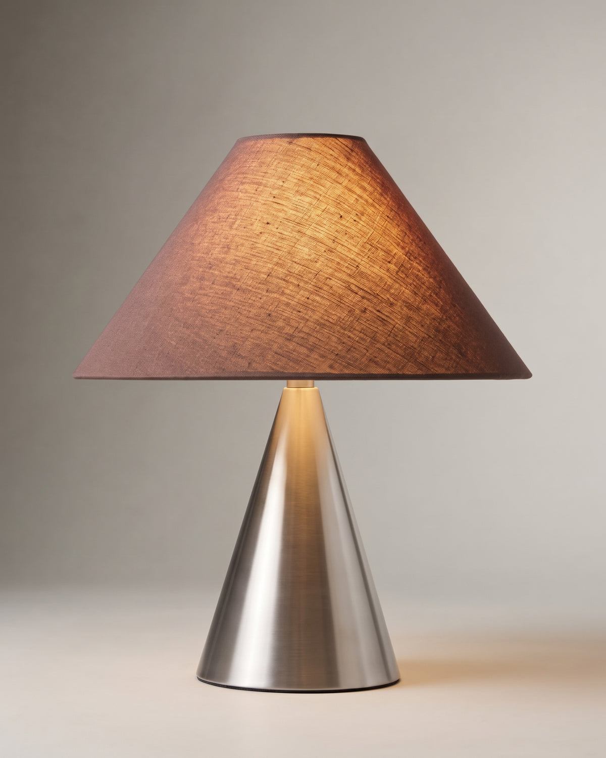 lampe de table KHONE allumée, pied conique en métal brossé et abat-jour brun prune