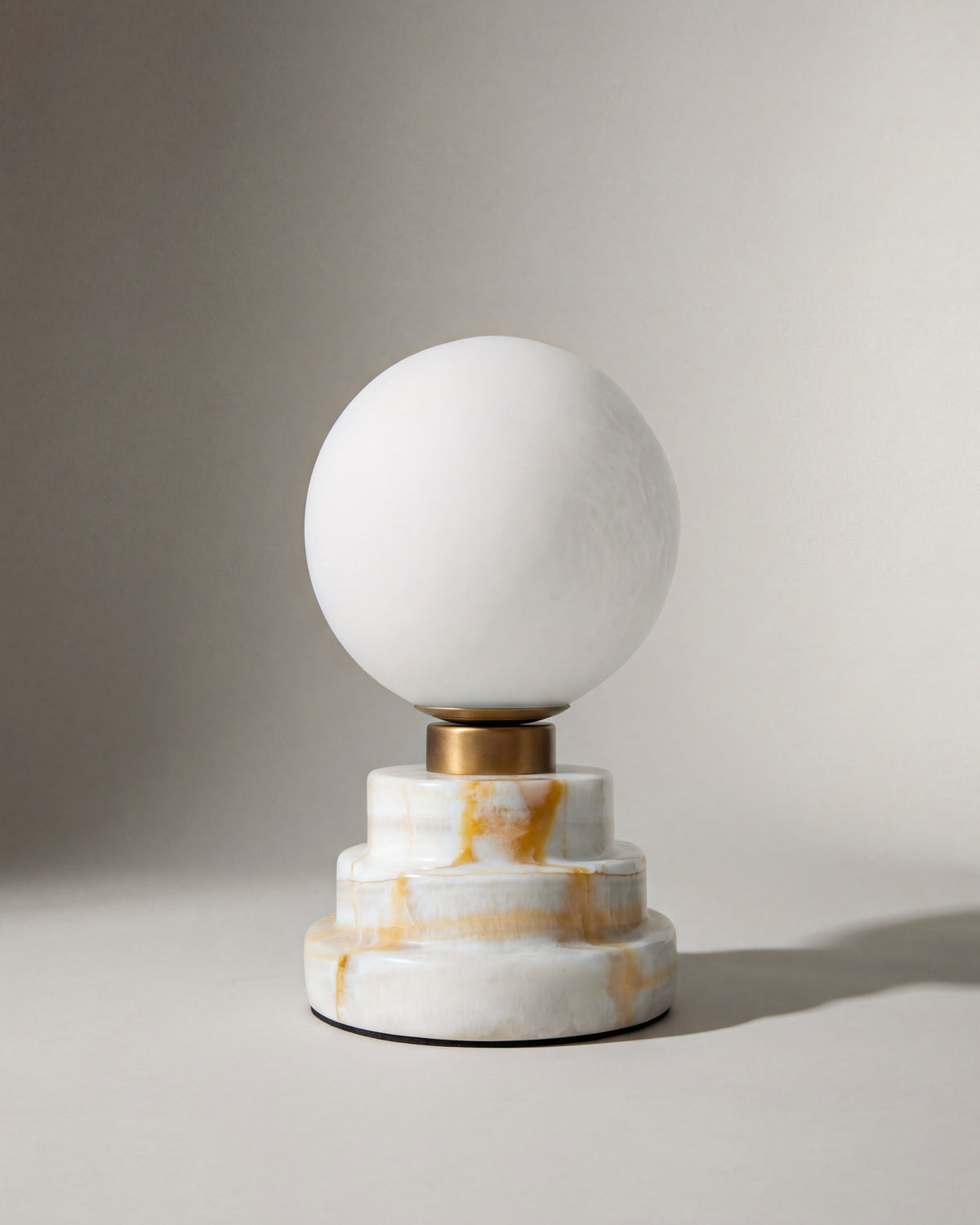lampe de table LUNARIS éteinte, globe en albâtre et base à gradins en onyx veiné d'ocre