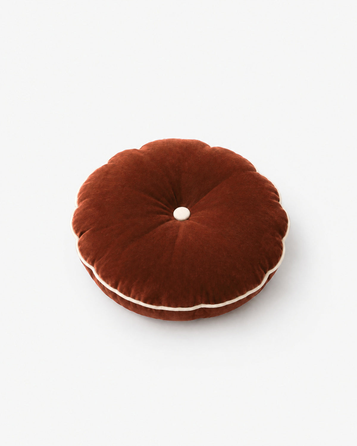 coussin rond MOON en velours cognac à bouton écru et passepoil, vue de trois quarts