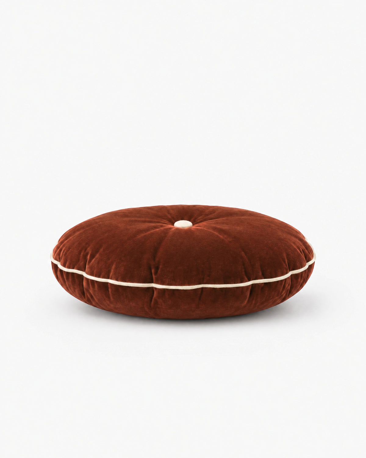 coussin rond MOON en velours cognac vu de profil, épaisseur et passepoil écru visibles