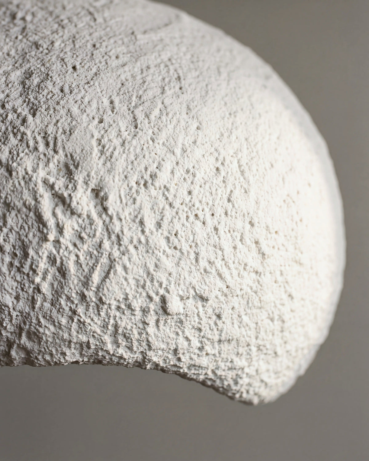 gros plan sur le grain minéral et poreux du plâtre blanc de la suspension MINORQUE