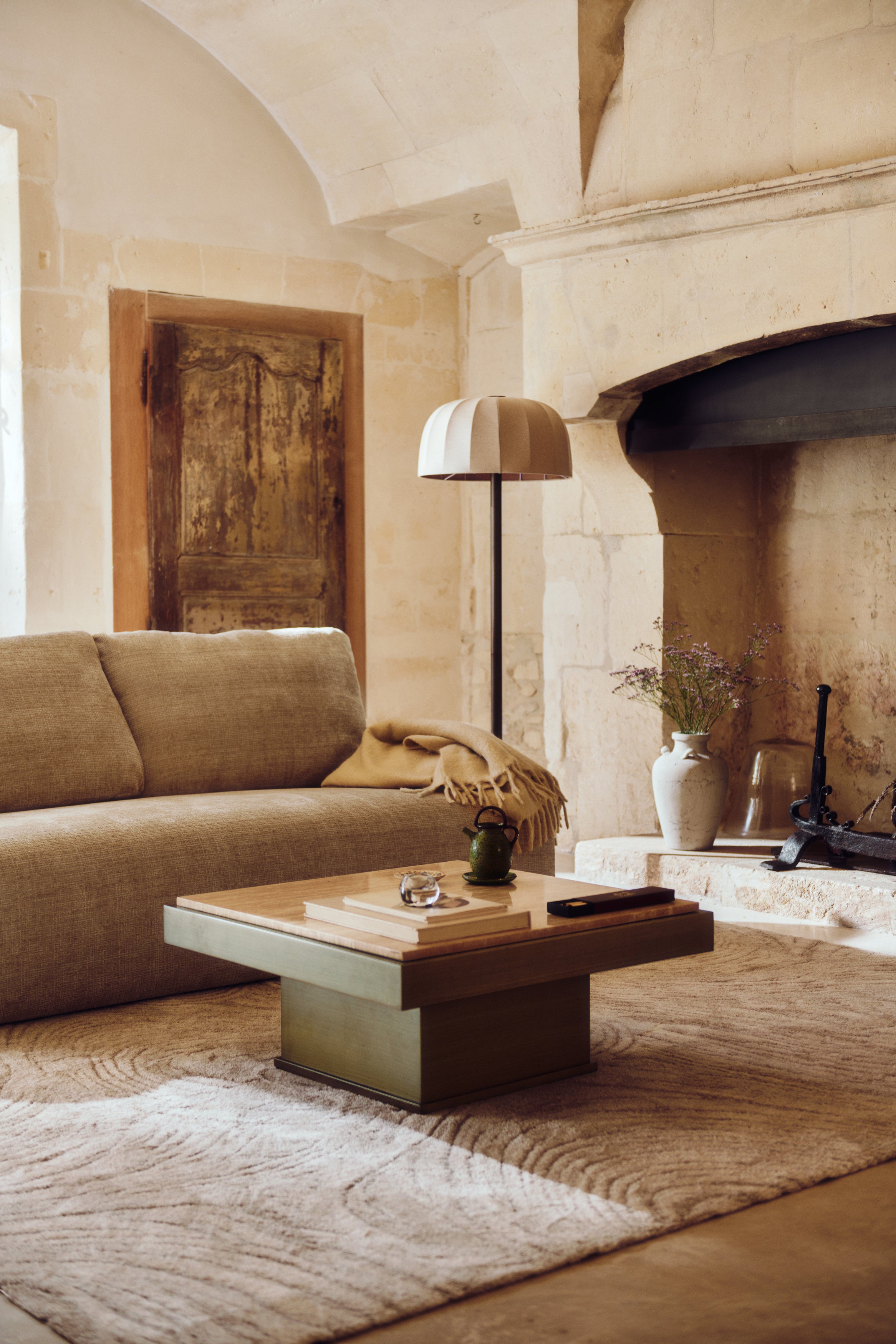 table basse Oron - plateau travertin et structure bois teinté - mise en situation salon