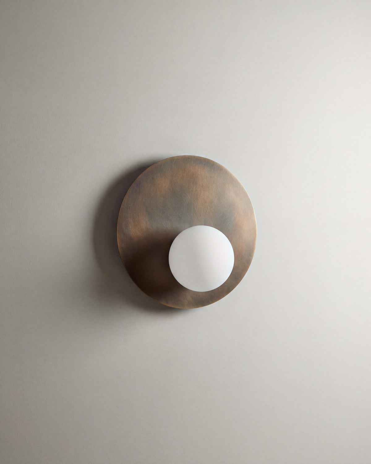 applique murale OLUWA, disque en métal bronze patiné et globe opalin, vue de face