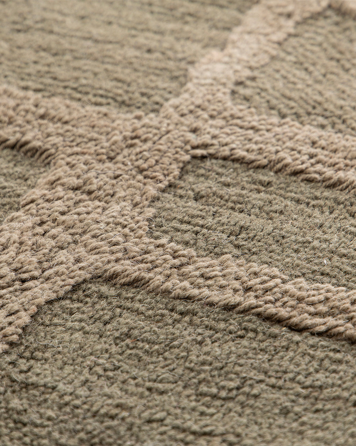 gros plan sur les lignes en relief ton sur ton d'un tapis de salon Strato vert kaki