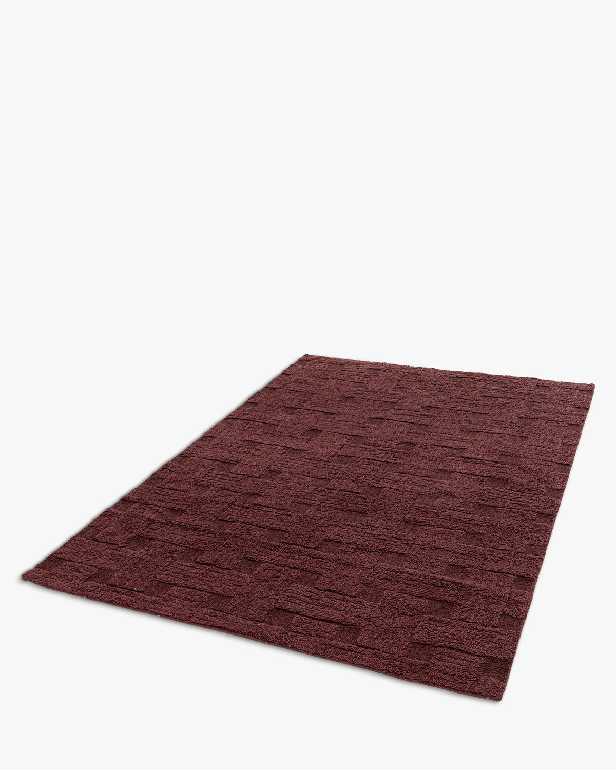 tapis de salon Woven rectangulaire bordeaux à motif tressé en relief - vue de trois quarts