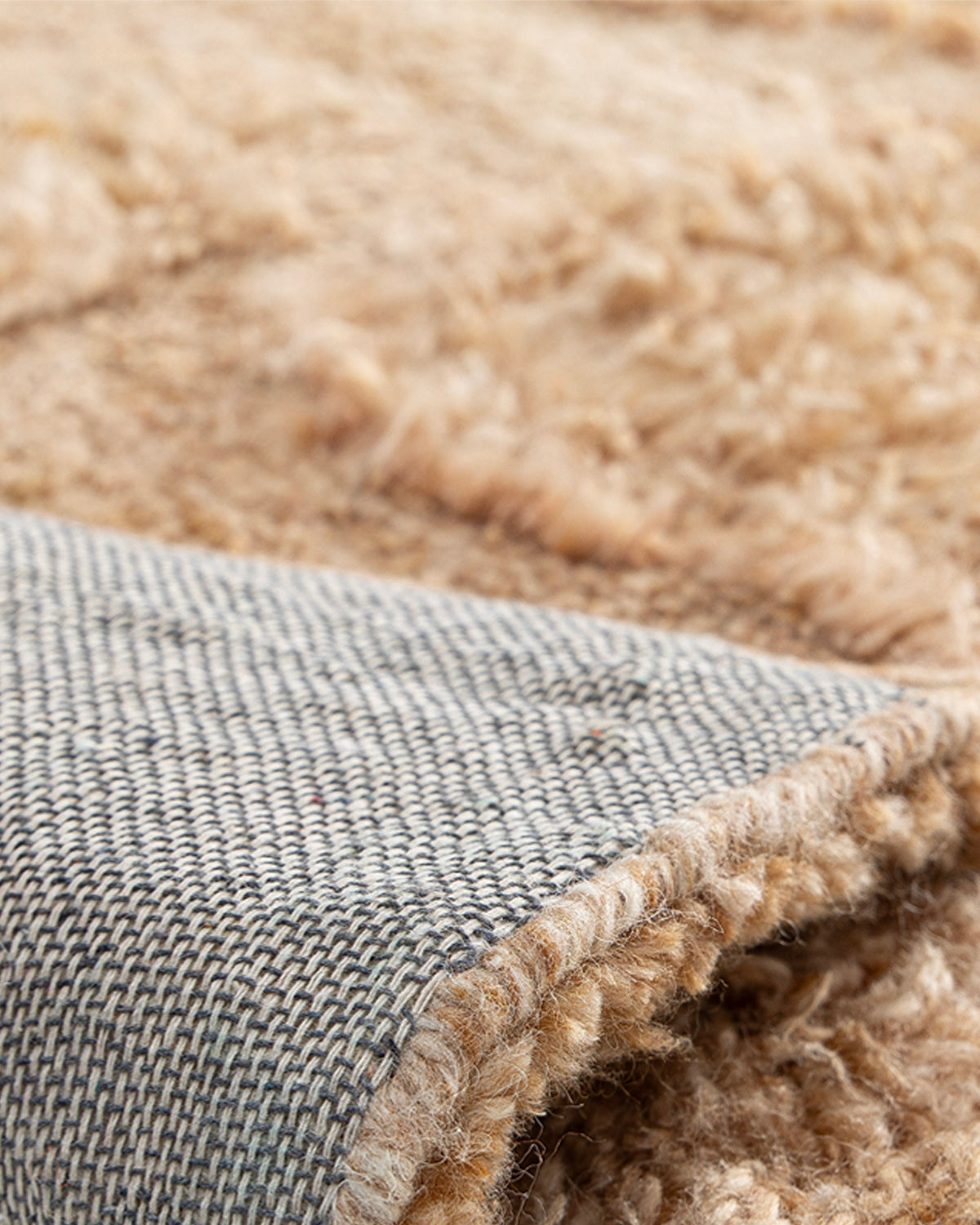gros plan sur les poils longs et bouclés du velours beige chiné d'un tapis Shard