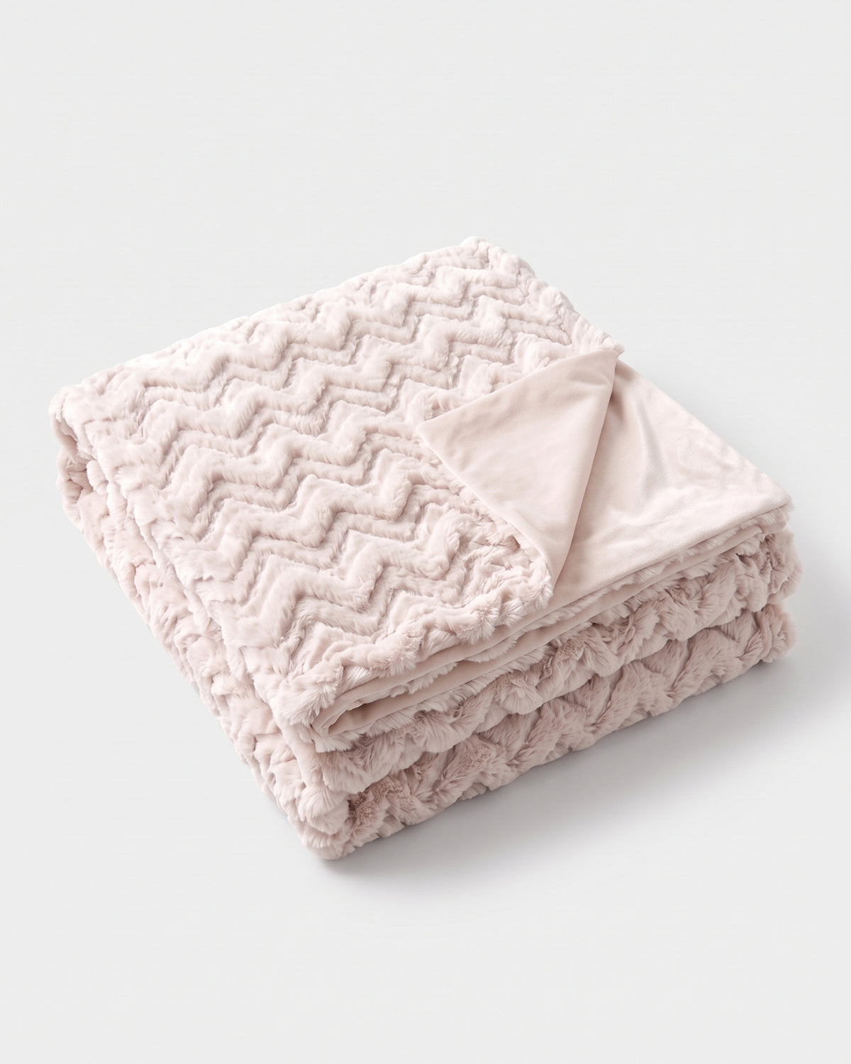 plaid EVEREST en fausse fourrure rose poudré à chevrons, plié avec son envers en velours uni