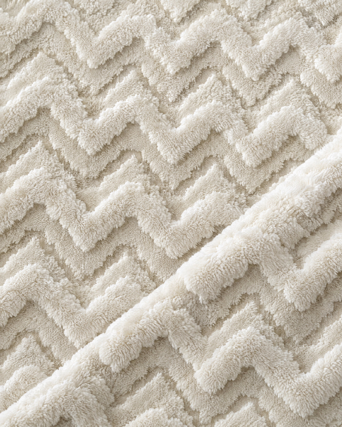 gros plan sur les chevrons en relief de la fausse fourrure écrue et beige du plaid EVEREST