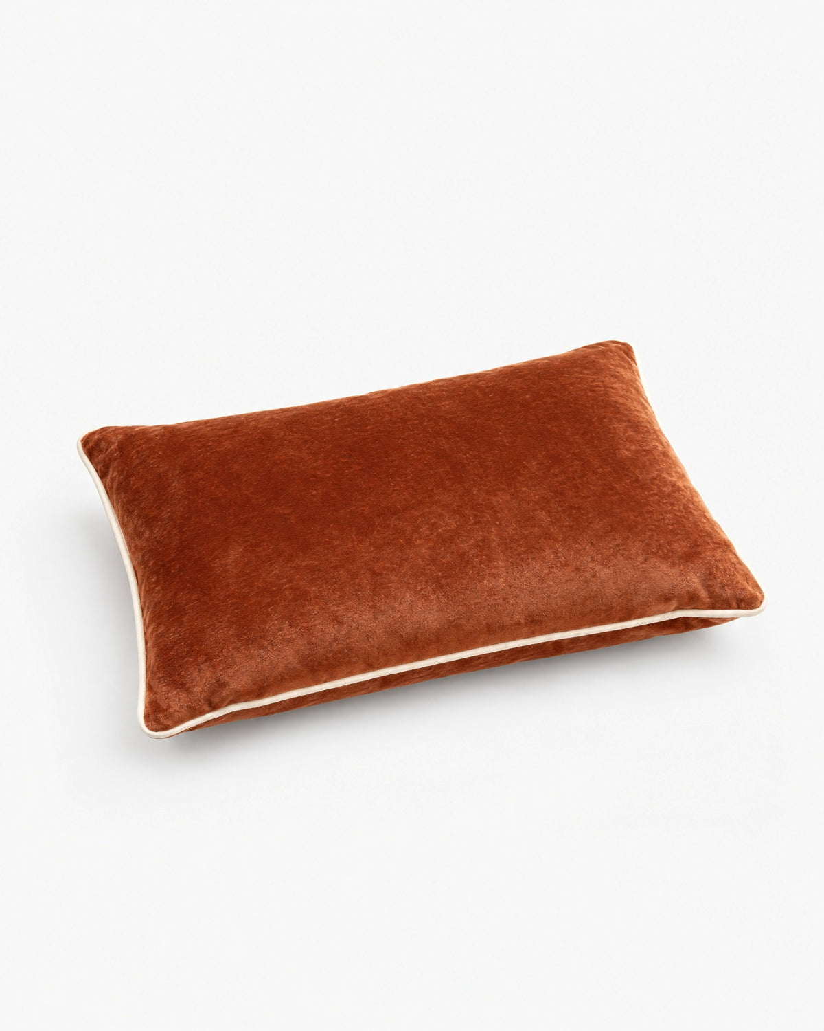 coussin rectangulaire LODGE en velours cognac à passepoil écru, vue de trois quarts