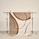 tapis SOLANO à motif abstrait beige, écru et brun, suspendu sur un portant de studio