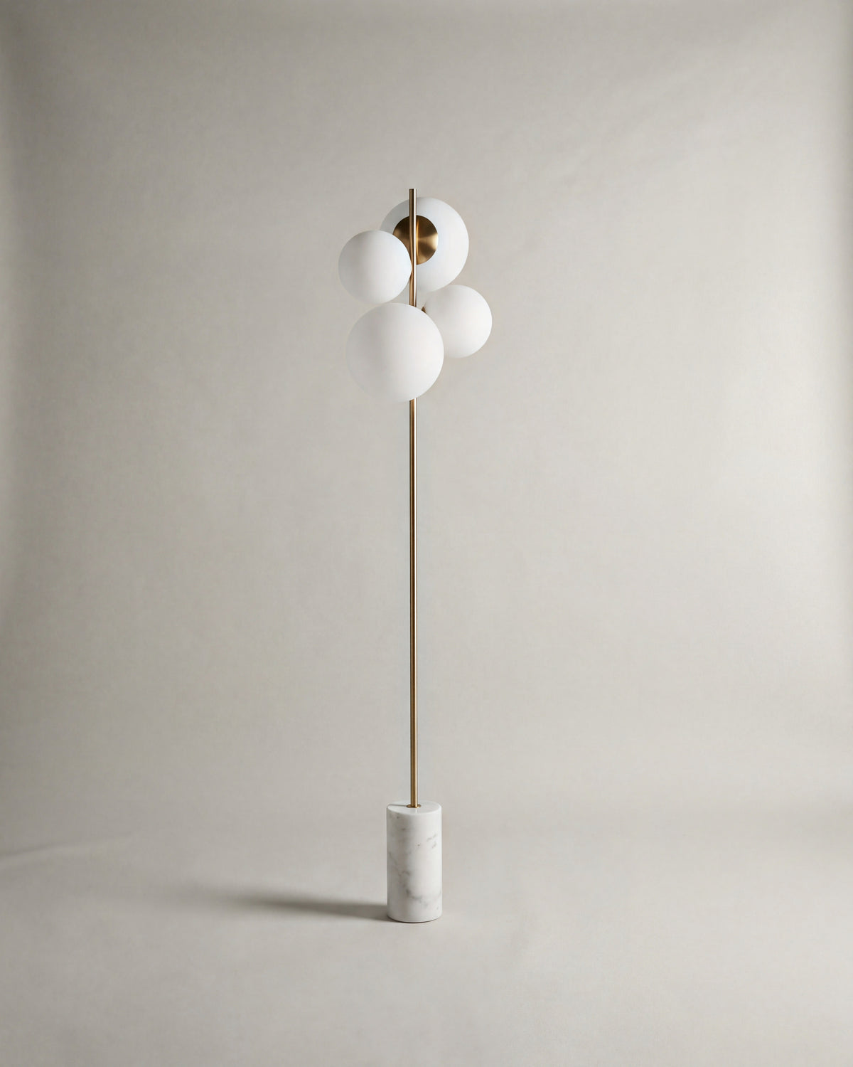 lampadaire SKULL éteint, quatre globes opalins sur tige laiton et base en marbre blanc
