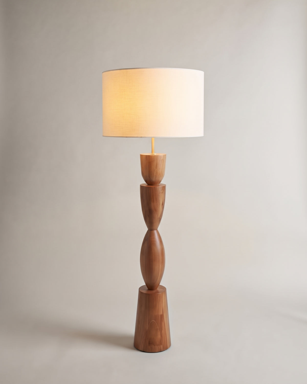 lampadaire TIKI allumé, abat-jour cylindrique écru sur un fût en bois tourné massif