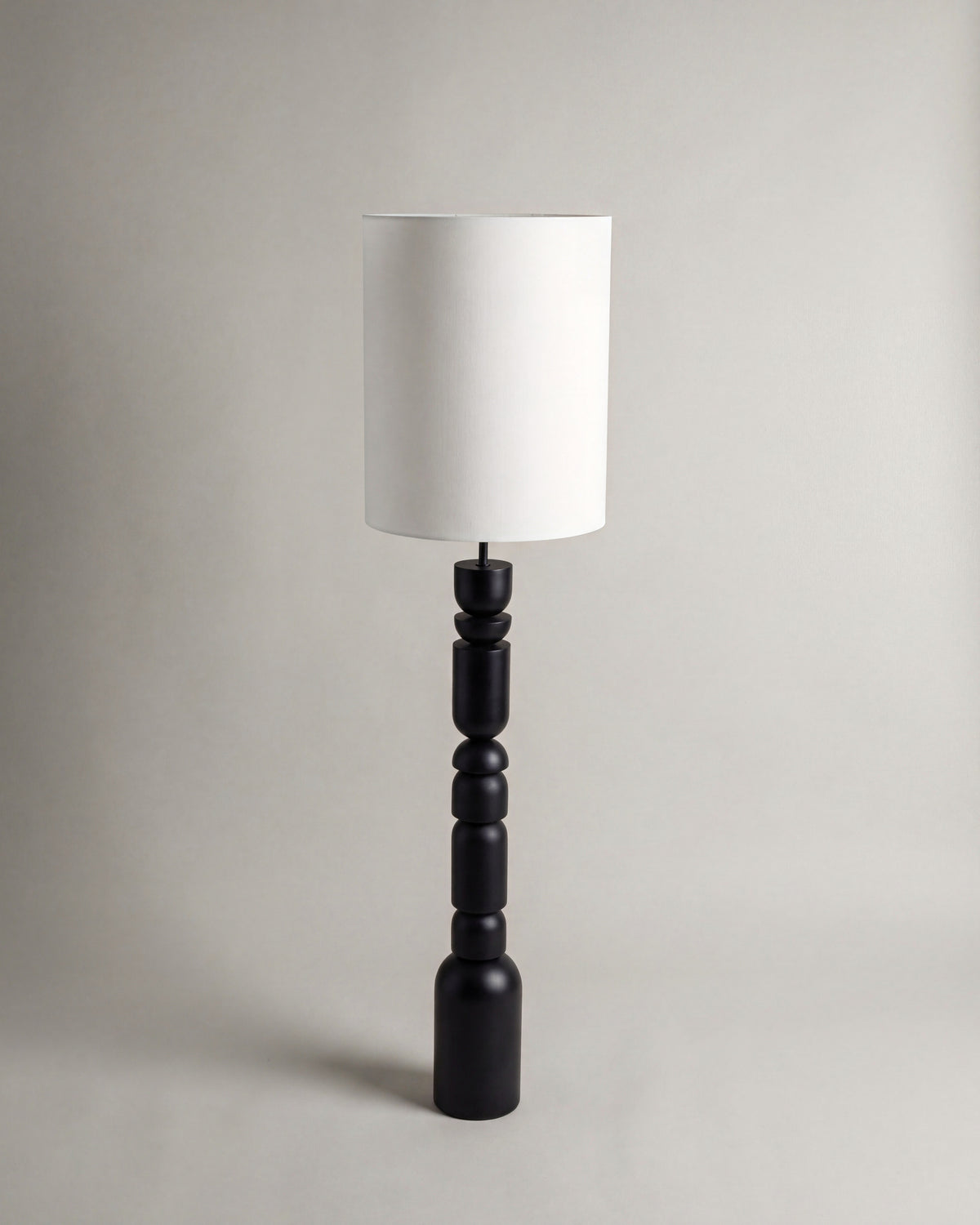 lampadaire TINGA éteint, abat-jour cylindrique écru et fût noir à modules empilés