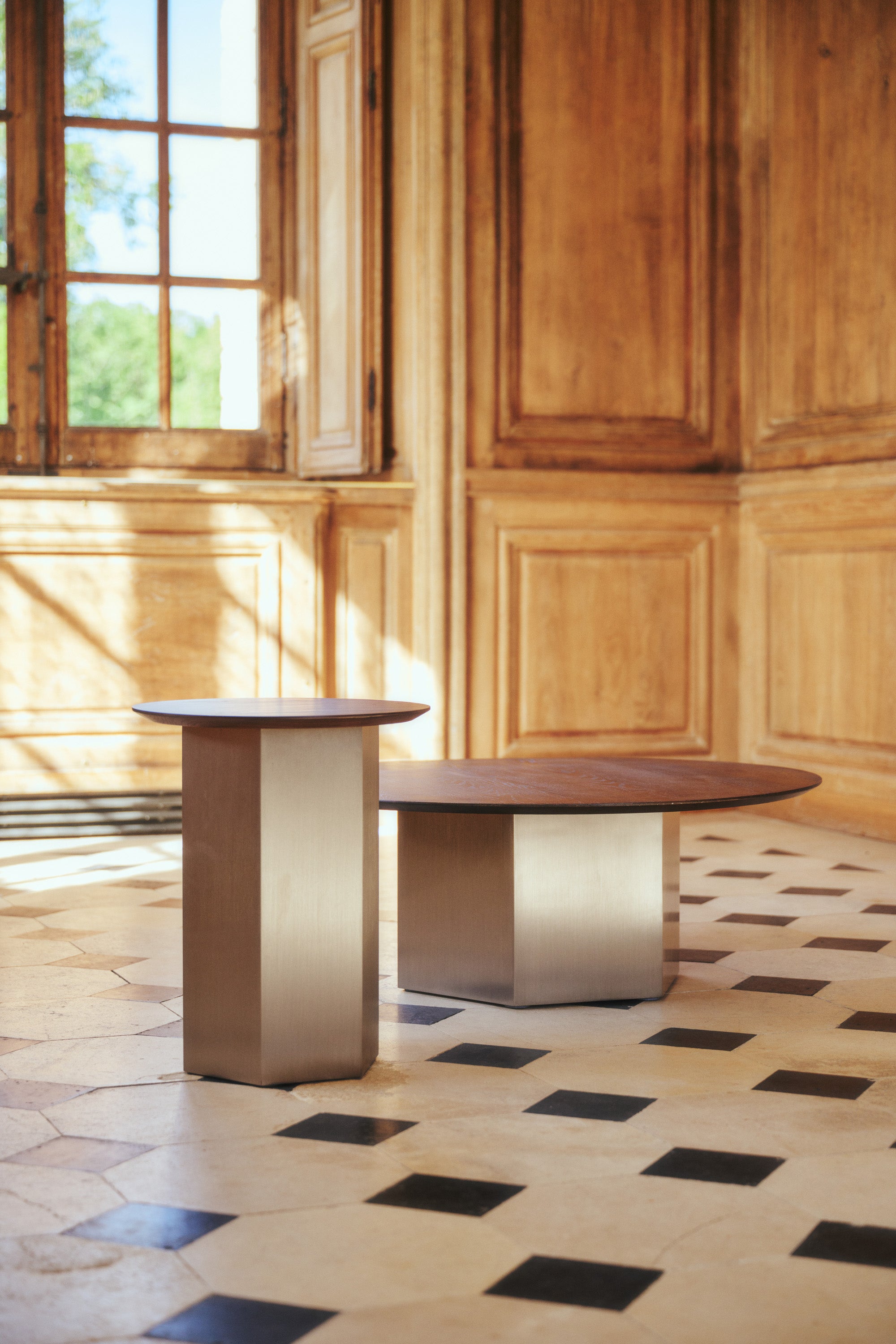 ensemble tables Hexa - plateau frêne massif teinte noyer et piètement acier inoxydable - vue trois quarts carrelage ancien